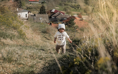 Kleinkind läuft bergauf in den Weingärten